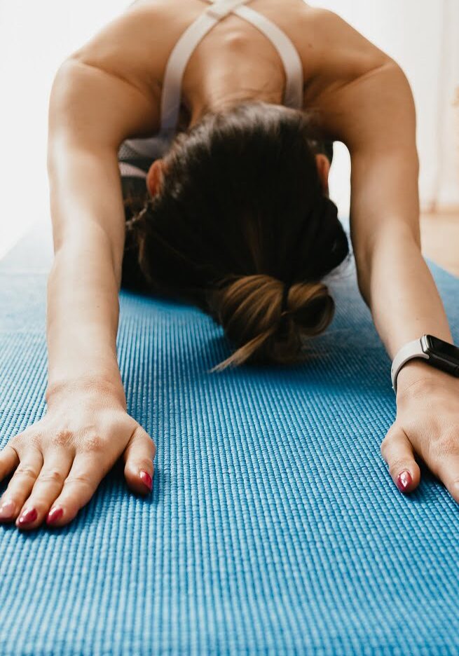 Frau bei einer Bodyart-Übung auf einer blauen Matte im Fitorama Fitnessstudio.