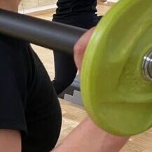 Ausschnitt von Teilnehmenden im Gruppenkurs Les Mills Bodypump mit Hantel auf der Schulter im Fitorama Gym in Basel