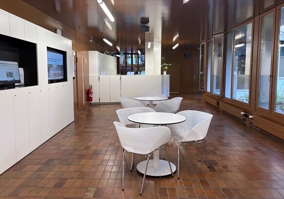 Eingangsbereich mit Bistrotischen im Unisport Fitnesscenter in Basel.
