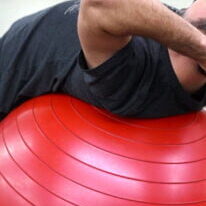 Kursteilnehmer beugt sich auf dem Rücken über Gesundheitsball im Gruppenkurs Rückenfit im Fitorama Fitnesscenter in Basel
