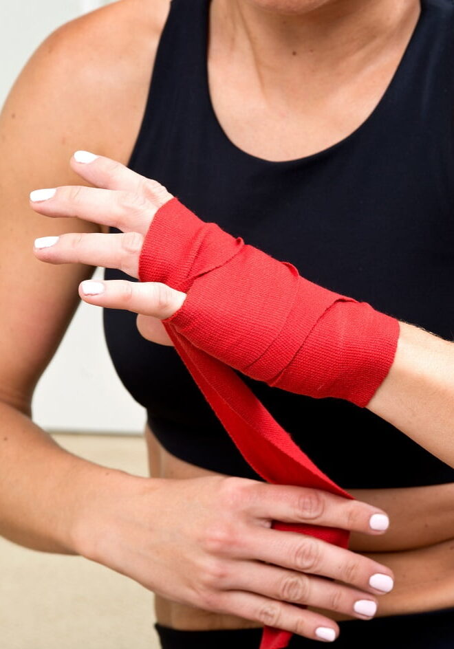Kursteilnehmerin bandagiert sich die Hand für den Gruppenkurs Toso X.