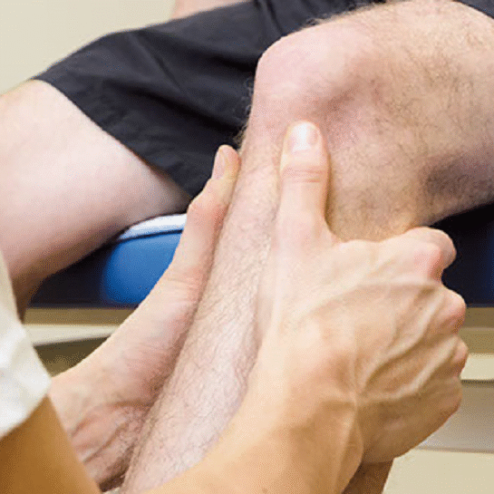 Physiotherapeut behandelt Knie eines Patienten im Physiorama - Physiotherapie und Oseteopathie